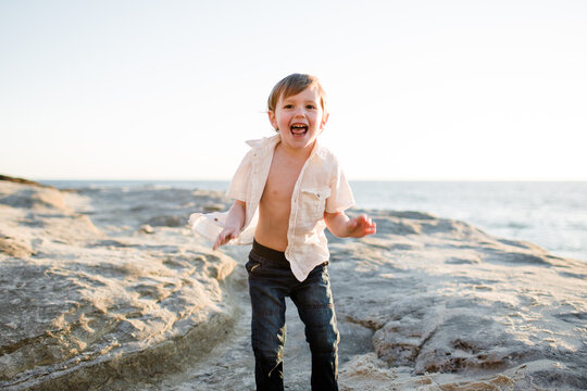 Excited Preschool Age Boy on Cliffs at Beach in San Diego