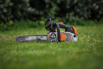 Used chainsaw detail on isolated green grass background.