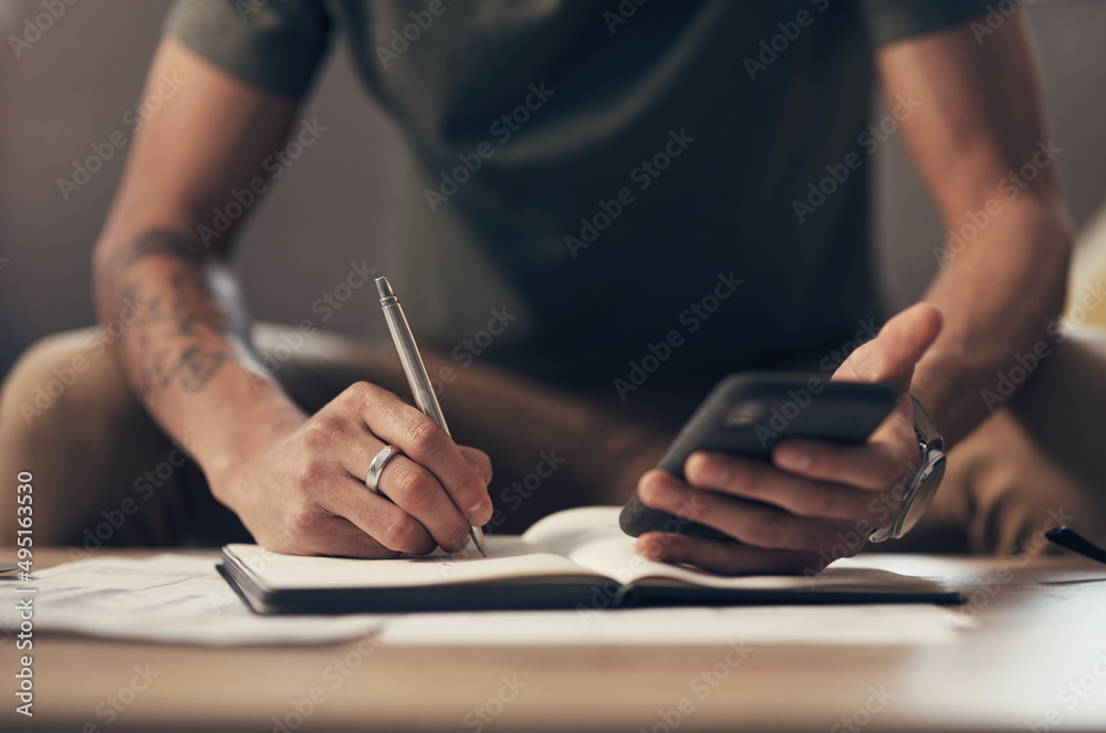 Poster The best personal finance app on the market. Shot of an unrecognisable man using a smartphone while going through paperwork at home.
