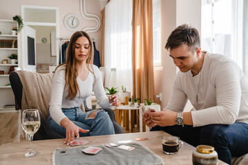 Two people man and woman young couple husband and wife brother and sister or boyfriend and girlfriend playing cards at home in bright day real people leisure games concept having fun copy space