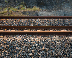 Naklejka premium The railroad tracks pass through the grooved bearings buried under the shards of cobblestone