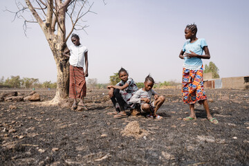 Group of bored young African girls aimlessly hanging around in the arid, desolate landscape of...