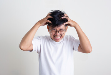 A young Asian man is stressed and anxious and has a white background.