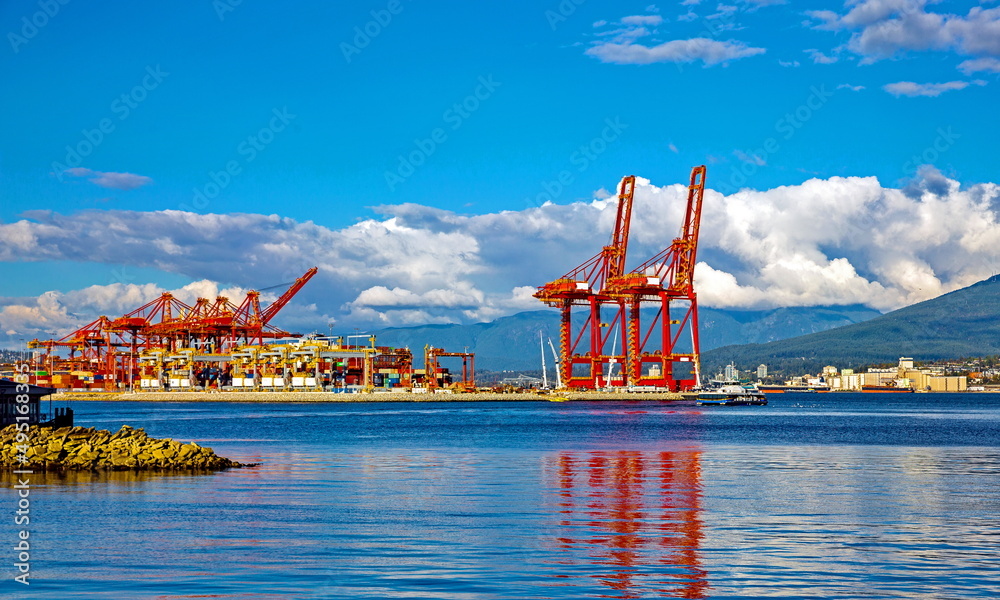 Wall mural place for loading ocean ships in the seaport of vancouver, against the backdrop of a blue cloudy sky