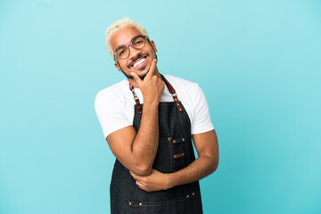 Restaurant Colombian waiter man isolated on blue background smiling