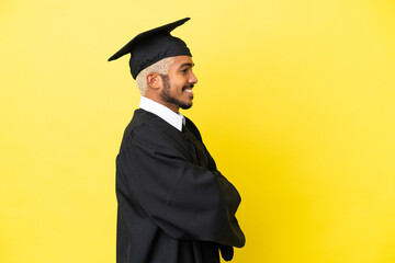 Young university graduate Colombian man isolated on yellow background in lateral position