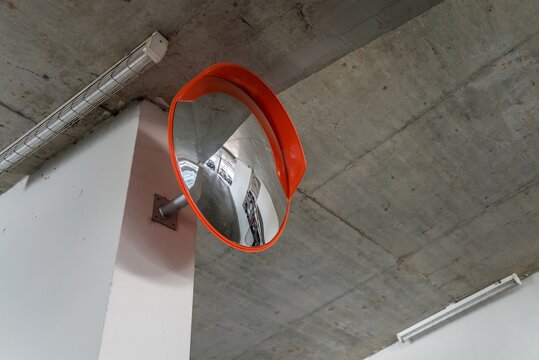 Indoor traffic surveillance convex mirror in building car parking area. Transportation and safety concept.