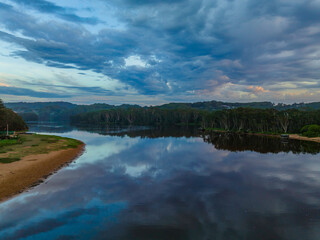 Sunrise reflections and clouds at the seaside with lagoon