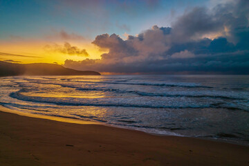 Fototapeta na wymiar Sunrise seascape with rain clouds on the horizon