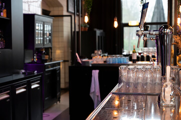 Interior of classic bar with beer taps and empty glasses in cafe