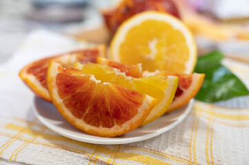Sicilian sweet juicy yellow and red blood oranges with green leaves close up