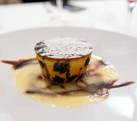 Tasty Italian dessert, small hot cake with chocolate and white gravy on white plate