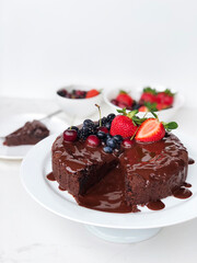 Chocolate cake with chocolate melted frosting and berries