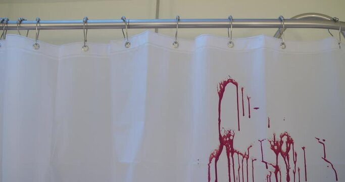 Medium shot of blood spraying on a shower curtain.