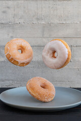 Flying donuts. Mix of multicolored doughnuts on gray background.