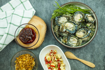 Raw oysters and side dishes in Thai style with spicy dipping sauce.