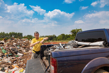 A man unloads his garbage from a pickup truck at a garbage dump in Paraguay.