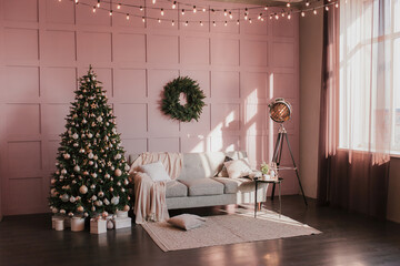 New Year's interior. Gray sofa on a pink wall with a Christmas tree