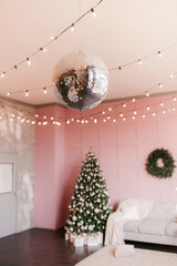 Disco ball in the New Year's interior on a pink background