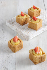 Small tartlet pastries topped with strawberry fruits.