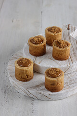 Lotus biscoff tartlet pastries topped with lotus biscoff spread and biscuits sprinkles.