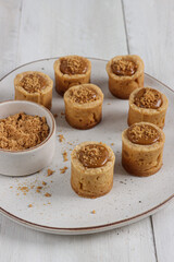 Lotus biscoff tartlet pastries topped with lotus biscoff spread and biscuits sprinkles.