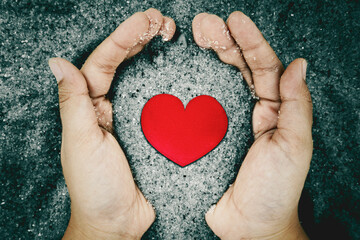 Unknown man hands hold sand with heart symbol