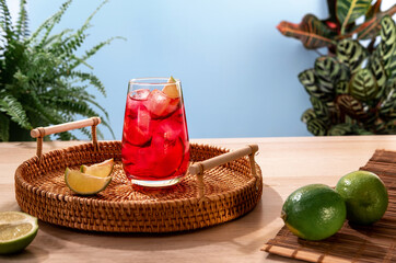Sparkling strawberry cocktail with ice on a wicker tray. Popular bright refreshing alcohol drink....