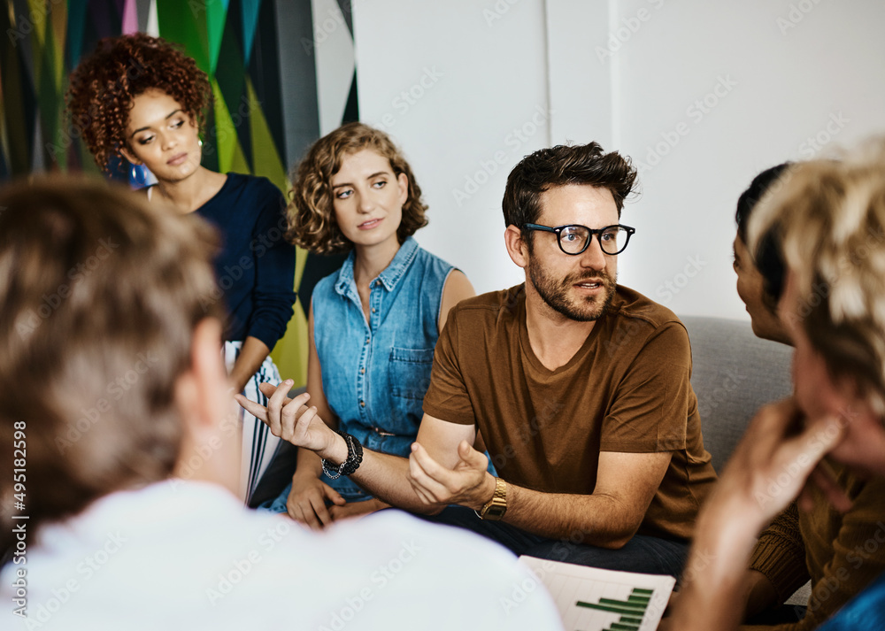 Poster exploring the possibilities. shot of a group of designers having a discussion in an office.