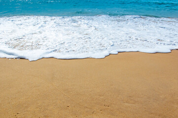 Sea Shore: Gentle waves reach the sand Sea Shore with Blue wave and white foamy summer background,