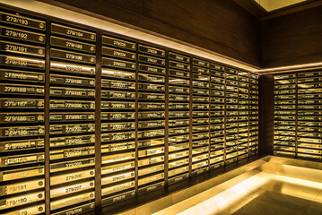 Mailboxes in apartment postal room with warm light decoration. Communication concept.