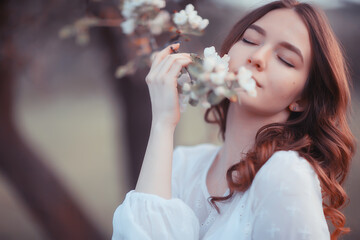 happy girl dreaming in a blooming garden, fresh tenderness spring woman in flowers