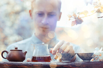 tea ceremony, Asian tea master prepares fresh spring green tea in the garden