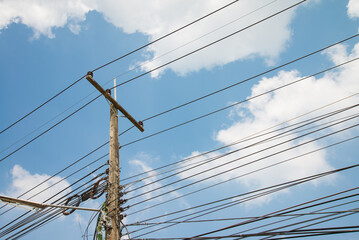 Fototapeta premium Electric pole transmission power line with blue sky background. Electrical energy and technology concept.
