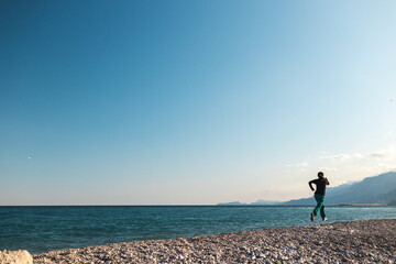 running on the sand, a woman runs along the beach