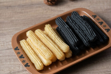 churros sticks typical of Spain with charcoal and vanilla