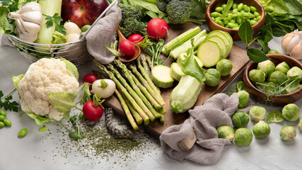 Raw and fresh spring vegetables on light background.