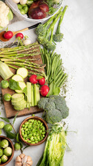 Raw and fresh spring vegetables on light background.