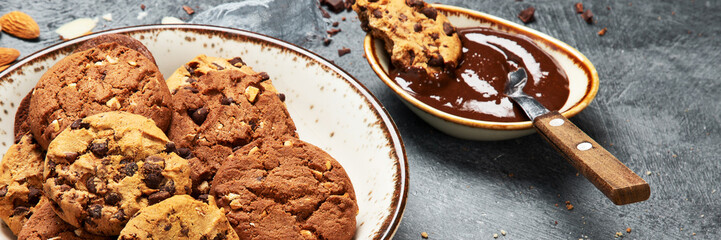Plate with chocolate cookies and cup of hot coffee. Sweet dessert.