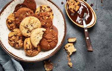 Plate with chocolate cookies and cup of hot coffee. Sweet dessert.