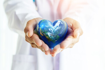 Hands hold Earth ball in heart shape on Doctor hands  for World Health Day content and copy space.Elements of this image furnished by NASA - 495193589