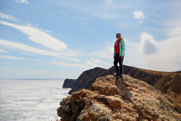 Lake Baikal in spring. A woman travels to the north of the island of Olkhon, Cape Khoboy. 