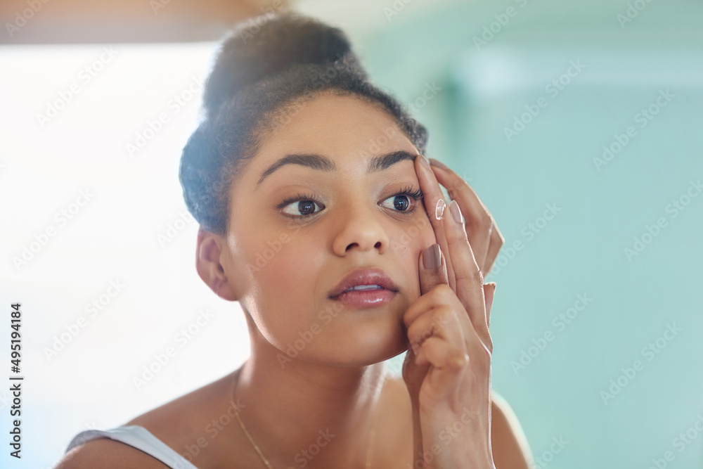 Sticker Helping her live the life she envisions. Shot of an attractive young woman putting in her contact lenses at home.