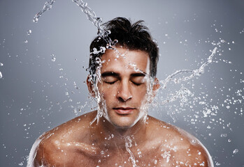 Getting clean. A young man splashing water on his face.