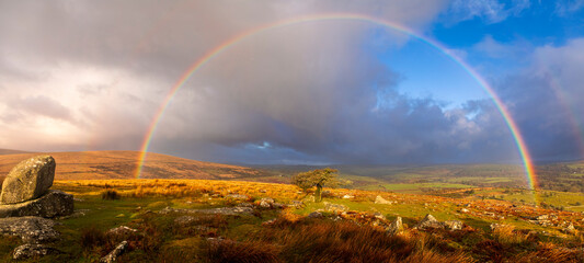 Vibrant rainbows over Combestone Tor on Dartmoor Devon in the west country of England UK