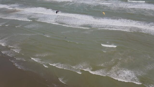 Aerial: Kite surfing at Muriwai beach, New Zealand