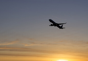 Naklejka premium Airplane in the sky at sunrise