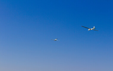 Ultra light, cessna plane drag on glider with prolonge rope on blue sky. Sport, aviation background
