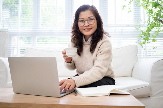Image of senior Asian businesswoman working at home