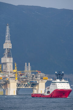 Hareid, Norway - 2022 March 24. Rig move of Equinor oil platform Njord Alpha with ahts vessel Siem Pearl innside the Norwegian fjord.